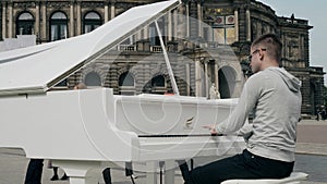 DRESDEN, GERMANY - MAY 2, 2018. Young man playing grand piano in historic centre of the city