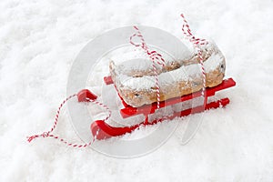 Dresdner Stollen, German Christstollen, on Red Wooden Sledge in Snow