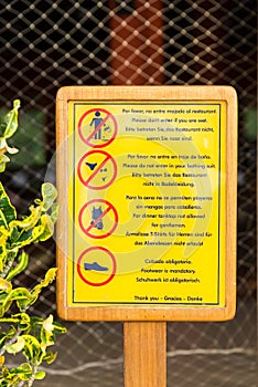 Dress code restricting sign at a restaurant next to a pool and beach (vertical)