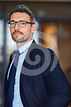 Dress how you want to be addressed. Portrait of a confident businessman in an office.