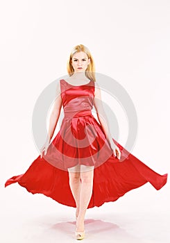 Dress rent service, fashion industry. Woman wears elegant evening red dress, white background. Girl blonde posing in