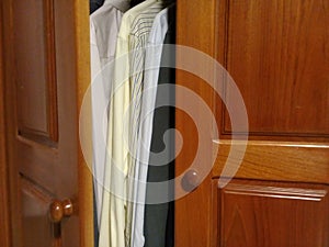 Dress shirts in the wooden closet with good light photo