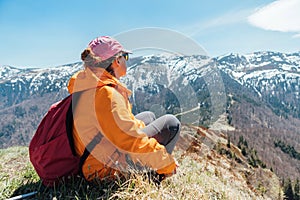 Oblečená zářivě oranžová bunda batohem žena sedící na kopci se těší zelené údolí v pohoří Malá Fatra, Slovensko.