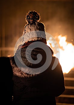 Dressed up for cold winter`s evening outside in front of fire