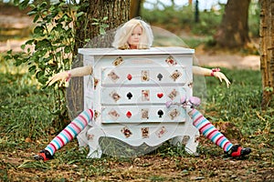 Dresser with doll Alice inside near Humpty Dumpty and mushrooms art object on outdoor art exhibition