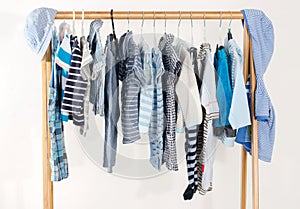 Dressing closet with clothes arranged on hangers.