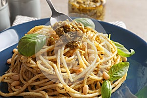 Dressing delicious pasta with basil pesto sauce