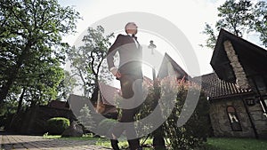 Dressing man straightens bow tie. Silhouette of man adjusting bowtie preparing for date or event. Stylish caucasian