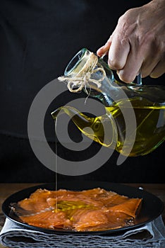 Dressing gravlax salmon with olive oil and dill