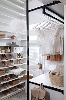 Dressing room interior with clothes rack and collection of stylish shoes