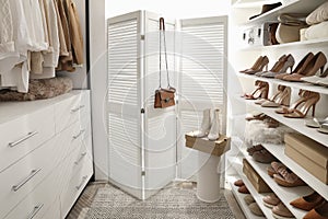 Dressing room interior with clothes rack and collection of stylish shoes