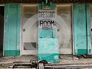 Dressing room only sign near two weathered doors