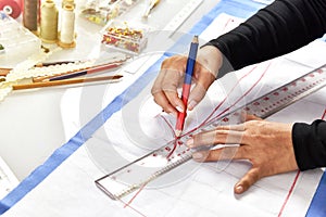 Dressmaker designer making pattern and measure garment. photo