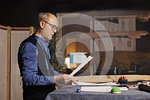 Dressmaker looking over sketch drawings