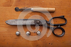 Dressmaker shears craft concept with polw and thimble on wooden