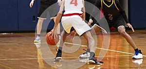 Dribbling between the legs during an indoor basketball game