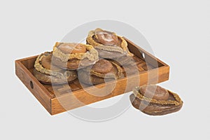 Dried abalone on bamboo tray in white background