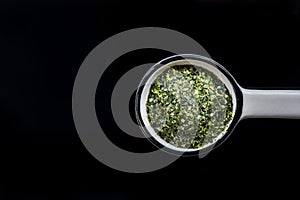 Dried aonori seaweed flakes on spoon