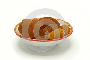 Dried apricots on a ceramic saucer isolated on white background. Energy and fiber natural source. Dieting food photo