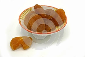 Dried apricots on a ceramic saucer isolated on white background. Energy and fiber natural source. Dieting food photo