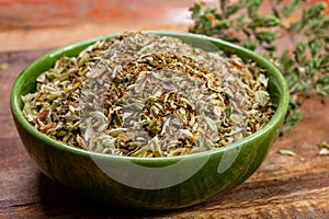 Dried aromatic kitchen herb oregano in green bowl