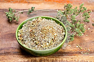 Dried aromatic kitchen herb oregano in green bowl