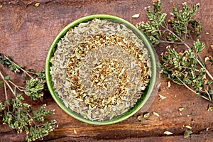 Dried aromatic kitchen herb oregano in green bowl