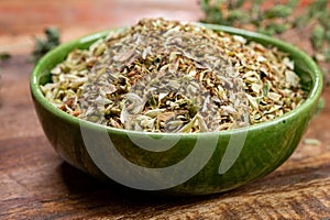 Dried aromatic kitchen herb oregano in green bowl