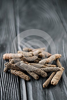 dried aromatic pippali long pepper on black wooden rustic background