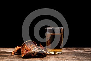 Dried bael fruit and bael juice on wooden floor.