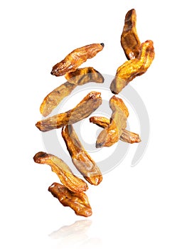 Dried bananas falling down on a white background