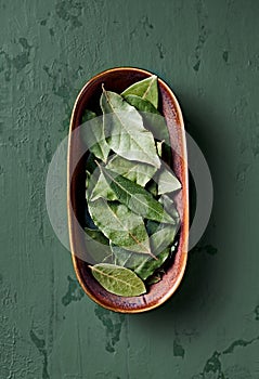 Dried bay leaves in a rustic ceramic dish. Natural, healthy spices