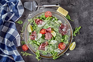 Dried beef bresaola. Salad bresaola arugula baby spinach tomatoes lime and cheese parmesan