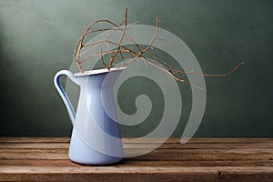 Dried branch in enamel jug