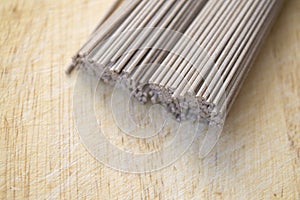 Dried buckwheat noodle on wooden cutting board