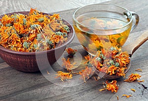 Dried calendula flowers in a wooden spoon. calendula tea. alternative medicine