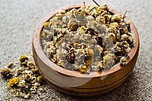Dried Camomile flower tea in wooden bowl papatya-bobune photo