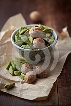 Dried cardamon pods and nutmeg in a dish