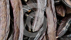 Dried carob fruit, close-up, a large amount of carob