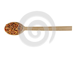 Dried carrot pieces on wooden spoon isolated on white background. Spices and food ingredients