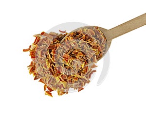 Dried carrot pieces on wooden spoon isolated on white background. Spices and food ingredients