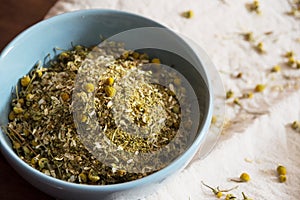 Dried chamomile inside blue bowl top view