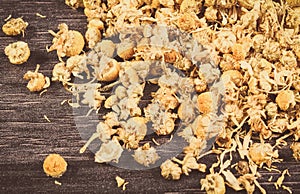 Dried chamomile on wooden board. Alternative medicine and herbalism photo