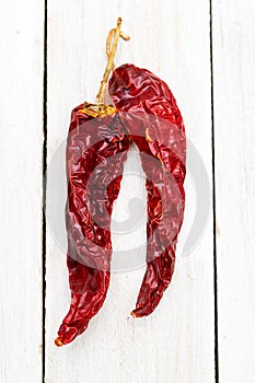 Dried chili peppers on white wooden background. Vertical