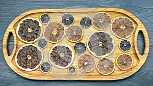 Dried citrus fruit pieces are laid out on a wooden board for product transfer. vitamin food