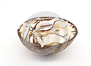 Dried coconut chips inside a coconut shell