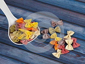 Dried colorful Italian pasta farfalle or bows with spoon