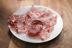 Dried coppa ham on white plate