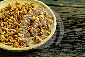 Dried cordyceps militaris in wooden dish on old wooden