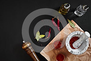 Dried and crushed red chili pepper in stone mortar. Copy space